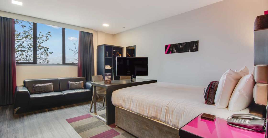 Smart Studio apartment with king size bed, sofa, wardrobe, television and desk.