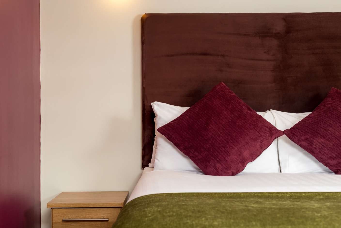 King Size Bed with headboard and dark red cushions